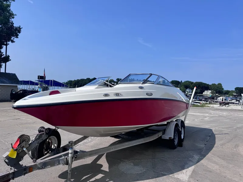 Slide: The Image of 2006 Sugar Sand Oasis boat on trailer, red and white design, parked outdoors. - 3