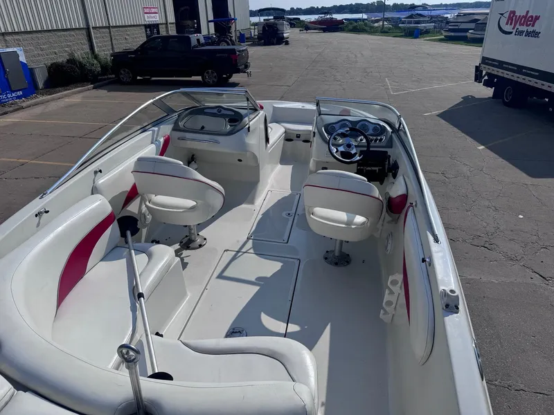 Slide: The Image of 2006 Sugar Sand Oasis boat interior with white and red seating, parked outdoors. - 7