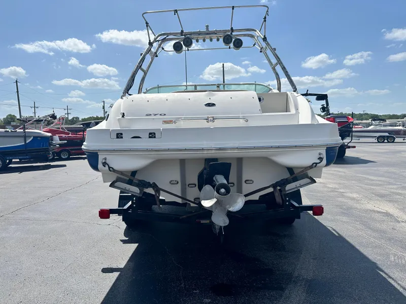 Slide: The Image of 2002 Sea Ray 270 SSI boat, rear view, parked on trailer under clear sky. - 2