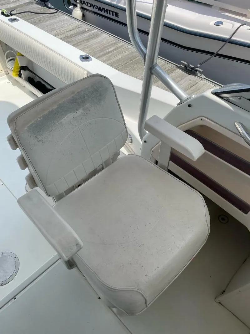 Slide: The Image of Grady-White 232 Gulfstream WA 2000 boat seat, white with armrests, docked in marina. - 15