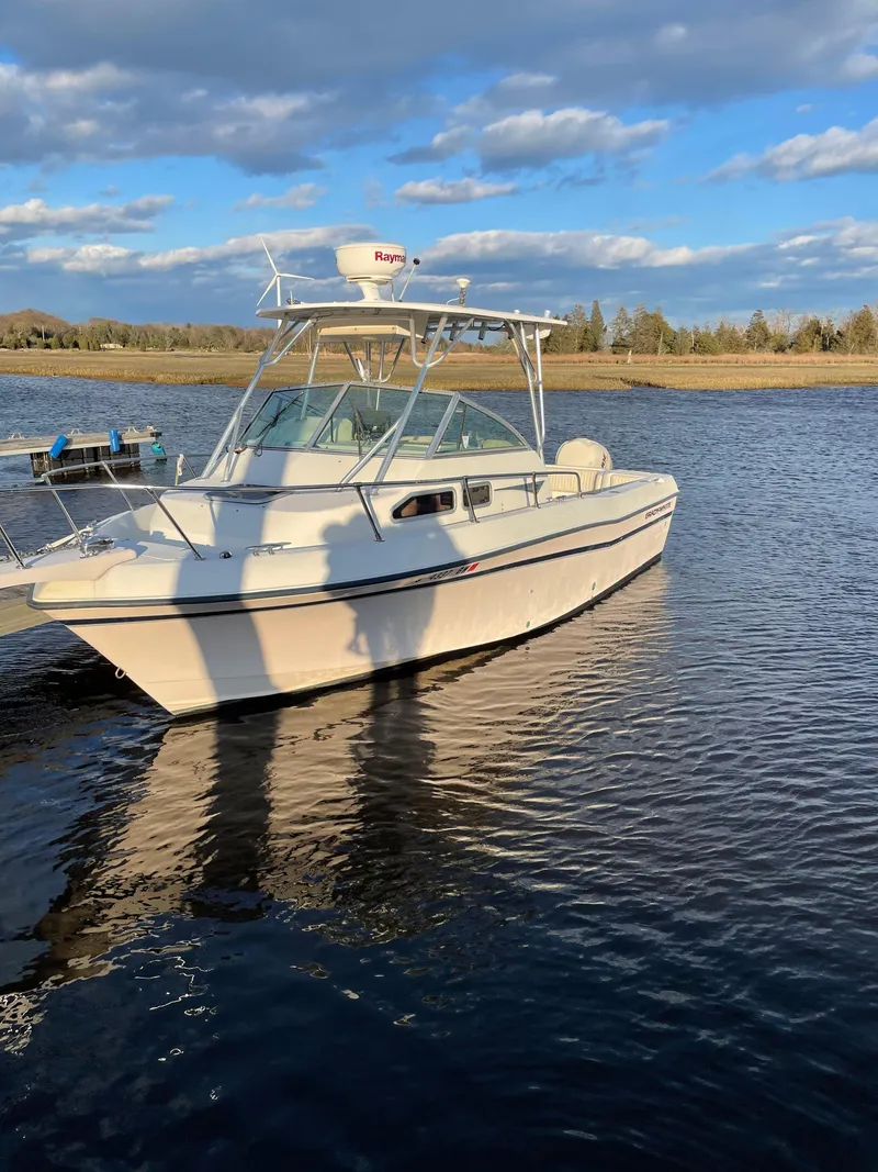 Slide: The Image of 2000 Grady-White 232 Gulfstream WA boat on calm water under blue sky. - 5