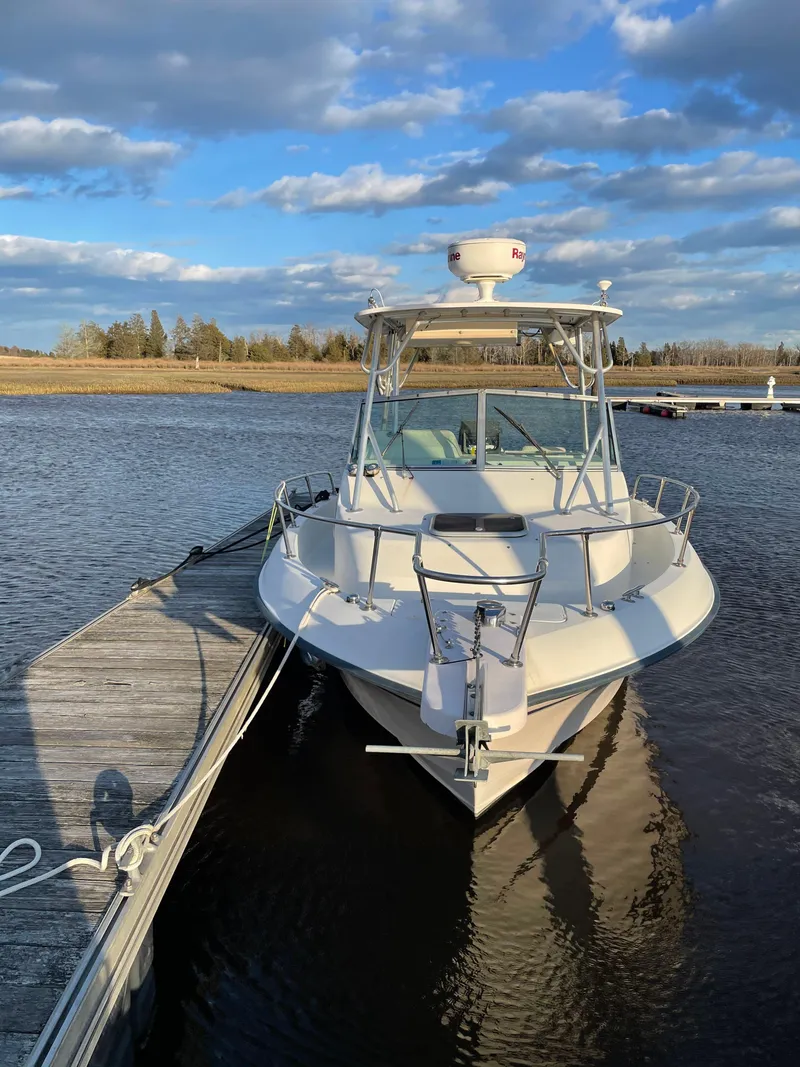 Slide: The Image of 2000 Grady-White 232 Gulfstream WA boat docked on calm water under blue sky. - 6