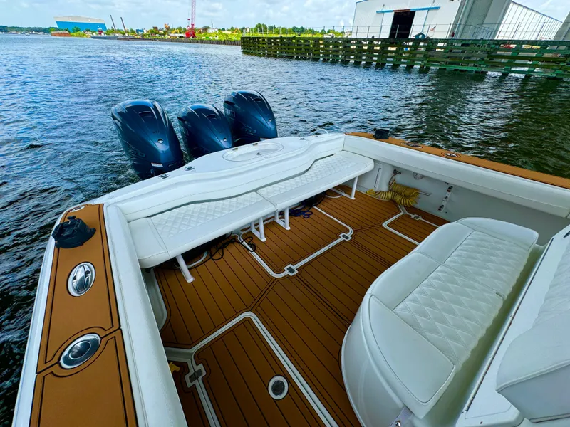 Slide: The Image of 2012 Yellowfin 39 Open boat with triple engines and teak deck, docked by the water. - 14