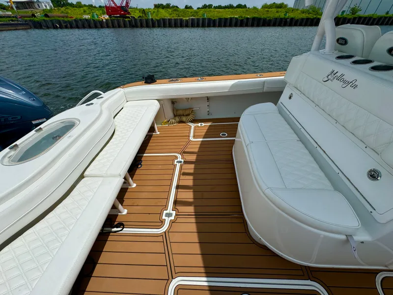 Slide: The Image of 2012 Yellowfin 39 Open boat interior with white seating and teak flooring. - 17