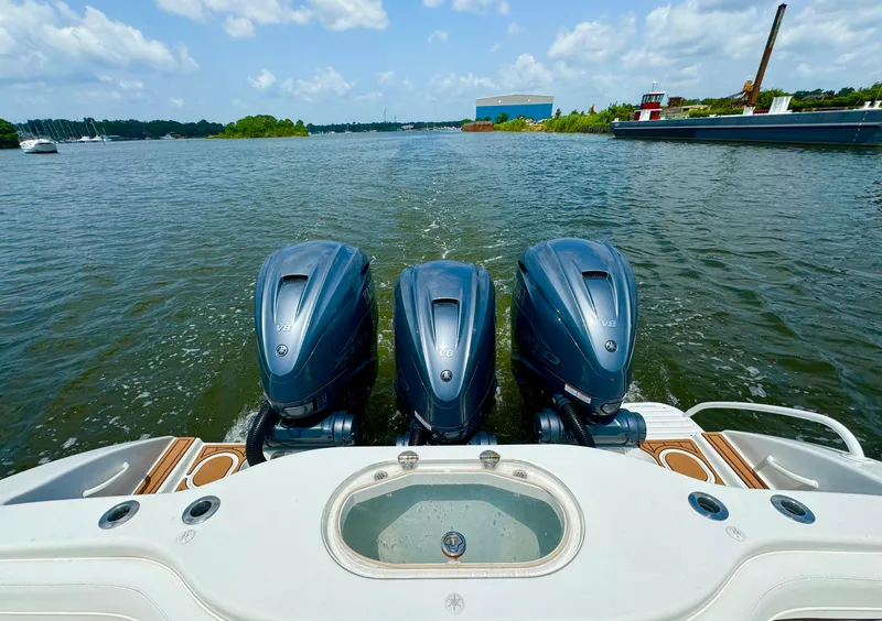 Slide: The Image of 2012 Yellowfin 39 Open boat with triple outboard engines on a calm waterway. - 18