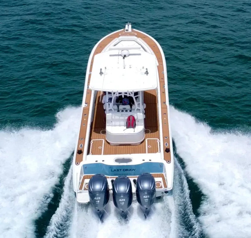 Slide: The Image of 2012 Yellowfin 39 Open boat cruising on water with triple outboard engines. - 2