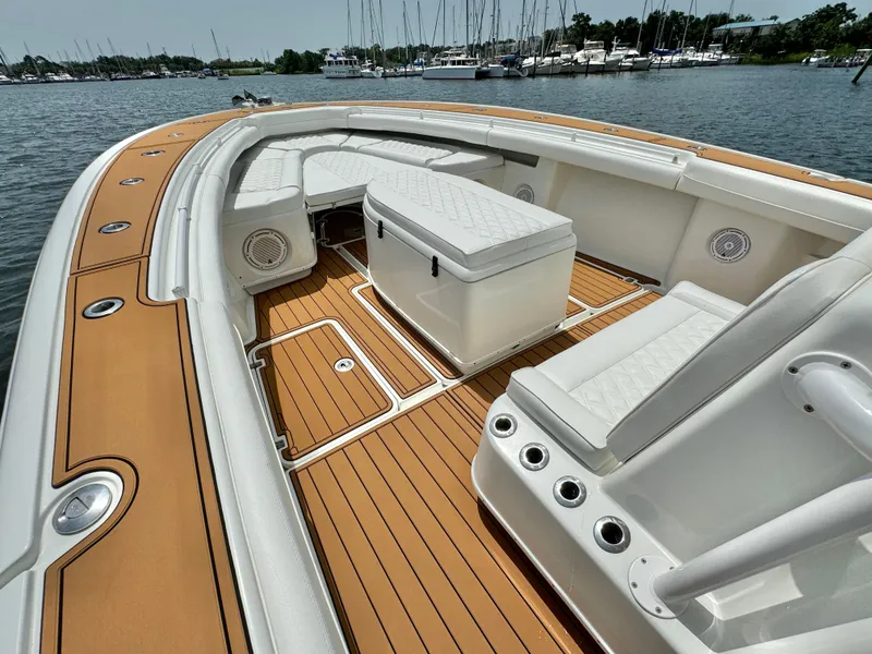 Slide: The Image of 2012 Yellowfin 39 Open boat with teak deck and white seating, docked by the marina. - 24