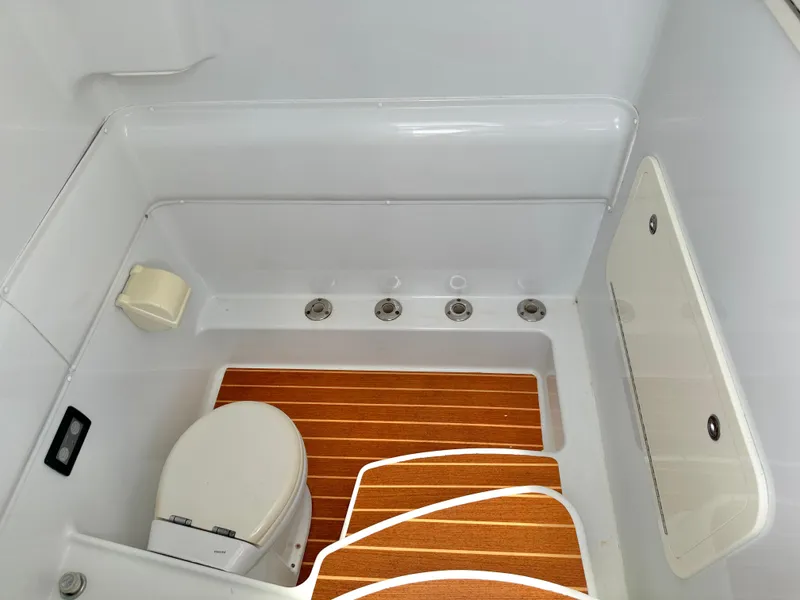 Slide: The Image of 2012 Yellowfin 39 Open boat bathroom with wooden flooring and white fixtures. - 26