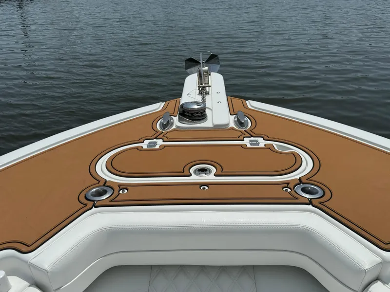 Slide: The Image of 2012 Yellowfin 39 Open boat deck with tan and white upholstery on water. - 27