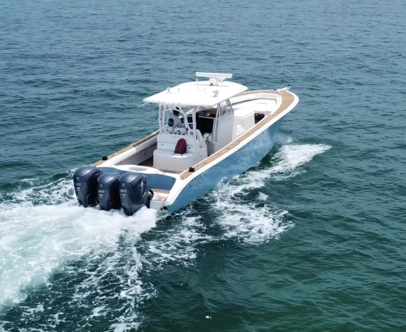 Slide: The Image of 2012 Yellowfin 39 Open boat cruising on the ocean with triple outboard engines. - 5