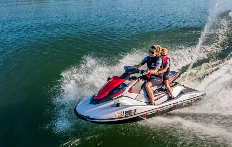 Slide: The Image of 2018 Yamaha WaveRunner EX Sport jet ski on water with two riders enjoying a sunny day. - 10