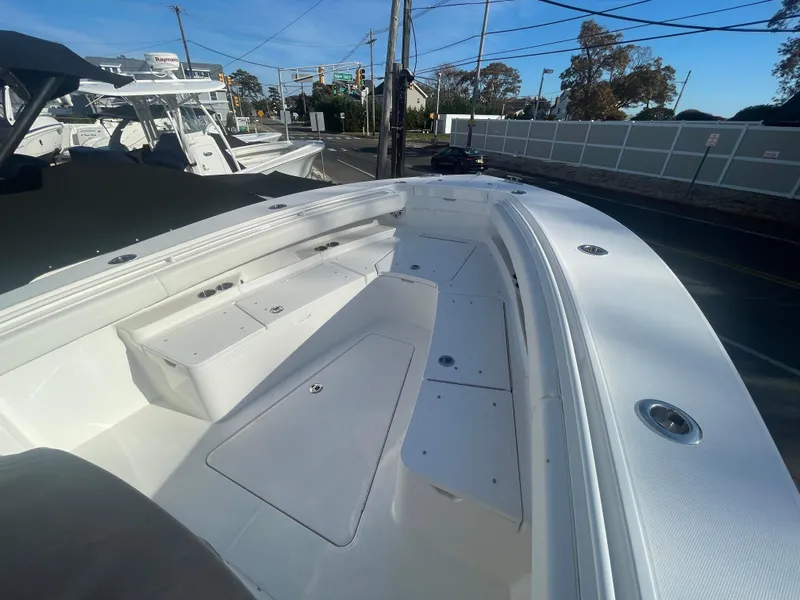 Slide: The Image of 2025 Regulator 28 boat, spacious deck, sleek design, white finish, outdoor setting. - 13