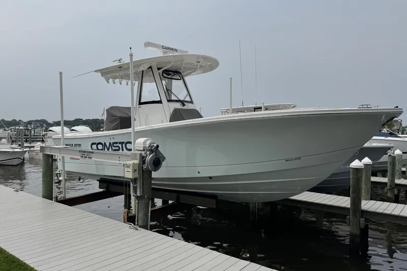 Slide: The Image of 2025 Regulator 28 boat docked at marina, featuring sleek design and modern equipment. - 2