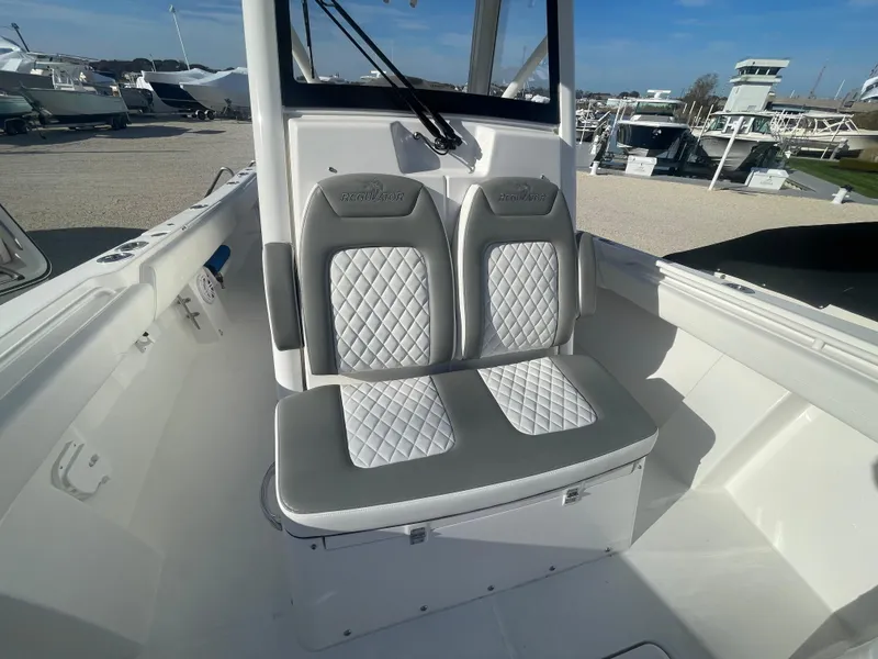 Slide: The Image of 2025 Regulator 28 boat with dual cushioned seats, white and gray interior. - 23