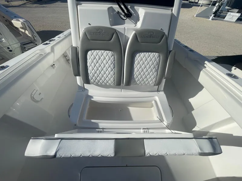 Slide: The Image of 2025 Regulator 28 boat with dual cushioned seats and storage compartment. - 24