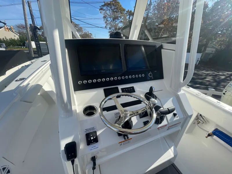 Slide: The Image of 2025 Regulator 28 boat dashboard with dual screens and steering wheel. - 26