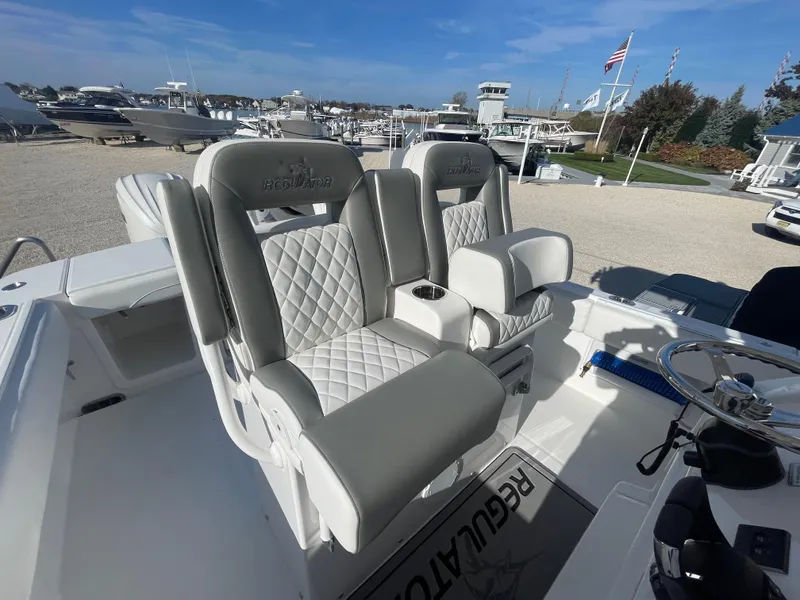 Slide: The Image of 2025 Regulator 28 boat with luxurious seating at a marina. - 34