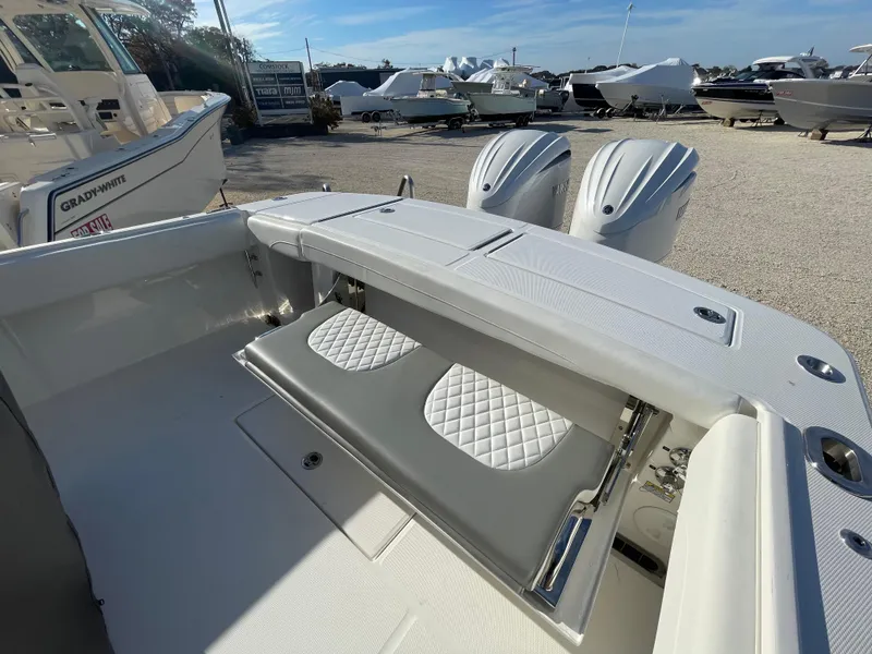 Slide: The Image of 2025 Regulator 28 boat with foldable seating and twin engines in a marina setting. - 40
