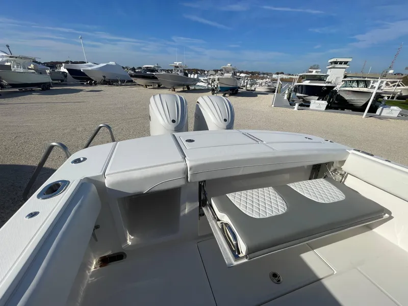 Slide: The Image of 2025 Regulator 28 boat with dual engines and foldable seating at a marina. - 41