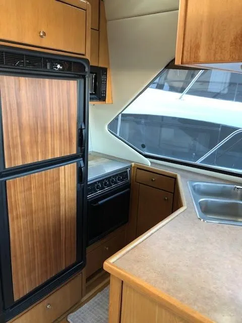 Slide: The Image of 2000 Bayliner 4087 Aft Cabin Motoryacht kitchen with wood cabinetry and modern appliances. - 13