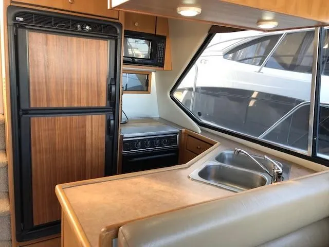 Slide: The Image of Interior of 2000 Bayliner 4087 Aft Cabin Motoryacht kitchen with sink, stove, and refrigerator. - 14