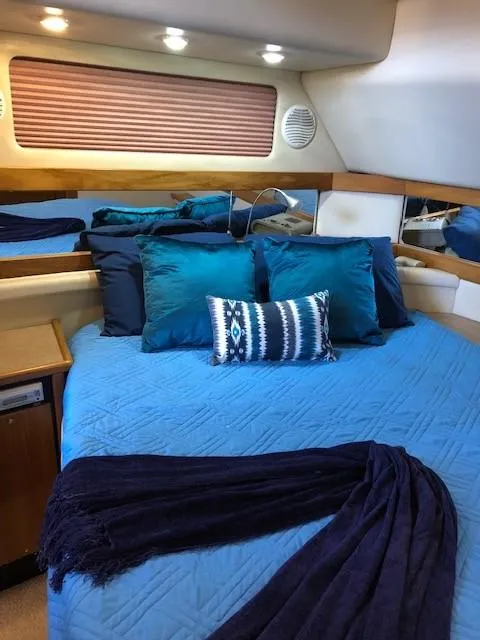 Slide: The Image of 2000 Bayliner 4087 Aft Cabin Motoryacht bedroom with blue bedding and decorative pillows. - 15