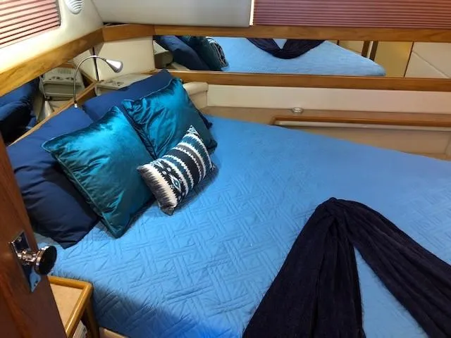 Slide: The Image of Bayliner 4087 Aft Cabin Motoryacht 2000 interior with blue bedding and decorative pillows. - 17