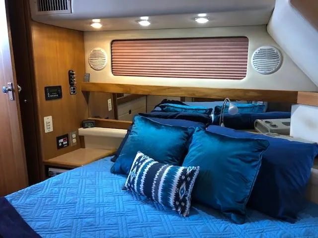 Slide: The Image of Interior of 2000 Bayliner 4087 Aft Cabin Motoryacht with blue bedding and wood accents. - 26
