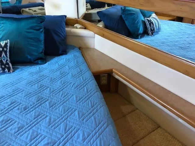Slide: The Image of Interior of 2000 Bayliner 4087 Aft Cabin Motoryacht with blue bedding and decorative pillows. - 29