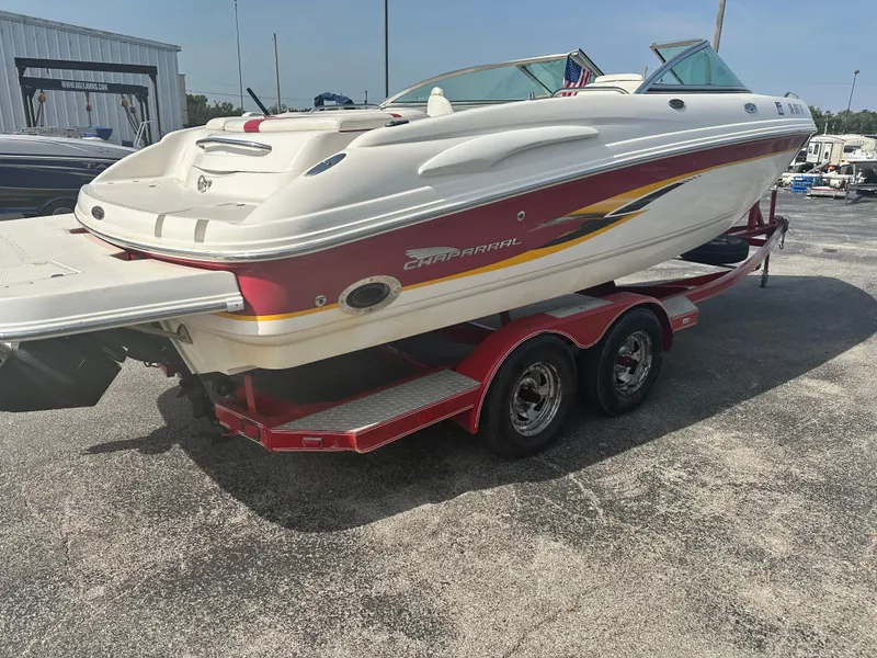 Slide: The Image of 2002 Chaparral 220WT SSi boat on trailer, red and white design, parked outdoors. - 3