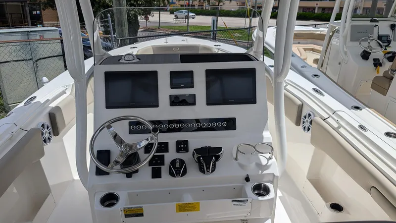 Slide: The Image of 2025 Key West 263 FS boat dashboard with dual screens and steering wheel. - 17