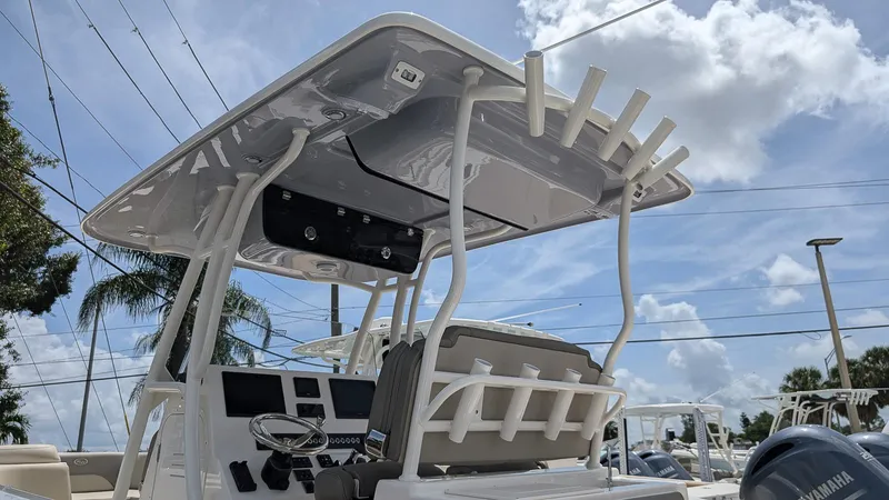 Slide: The Image of 2025 Key West 263 FS boat with T-top and rod holders under a sunny sky. - 24