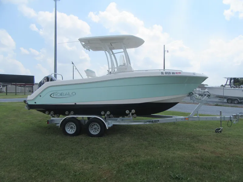 Slide: The Image of 2022 Robalo R222 Center Console boat on trailer, parked on grass. - 0