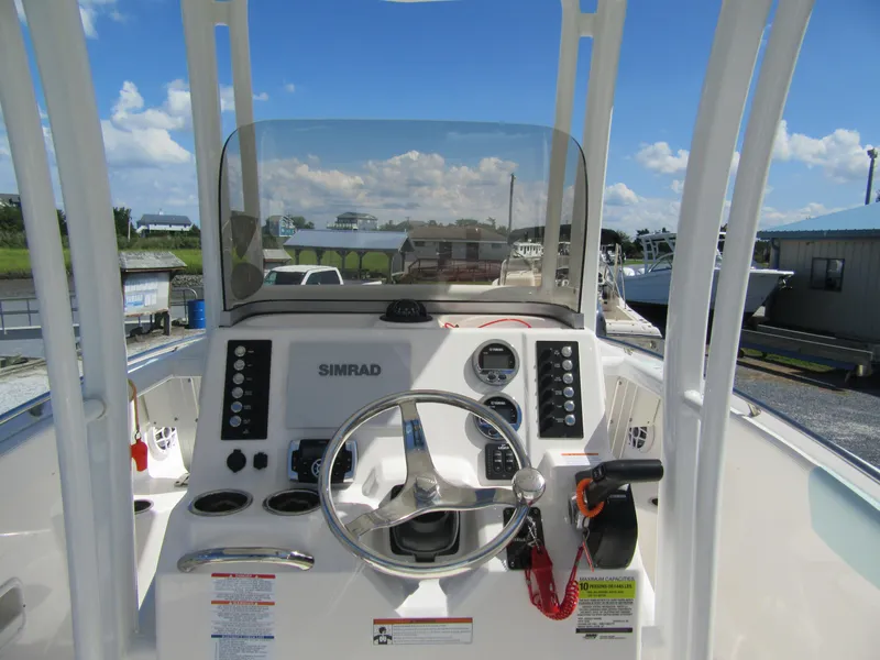 Slide: The Image of 2022 Robalo R222 Center Console boat dashboard with steering wheel and controls. - 2