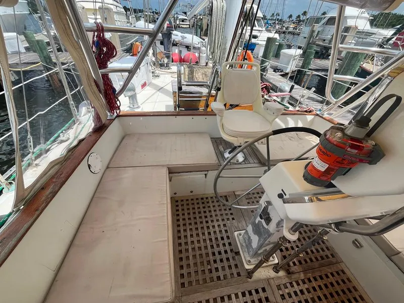 Slide: The Image of 1975 Cheoy Lee Offshore 53 MS cockpit with seating, steering wheel, and marina view. - 10