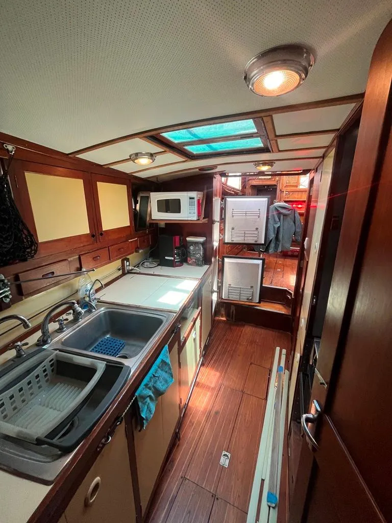 Slide: The Image of 1975 Cheoy Lee Offshore 53 MS yacht interior kitchen with wood finish and modern appliances. - 23