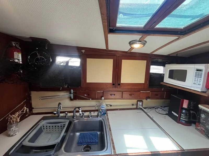 Slide: The Image of 1975 Cheoy Lee Offshore 53 MS yacht kitchen with sink, microwave, and storage cabinets. - 25
