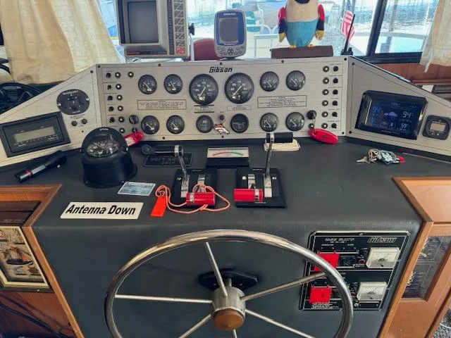 Slide: The Image of Control panel of a 1994 Gibson 44 Standard boat with gauges and steering wheel. - 10