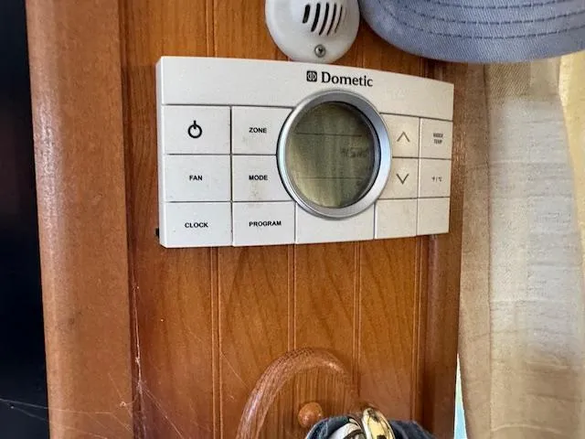 Slide: The Image of Dometic thermostat on wooden panel in a 1994 Gibson 44 Standard boat interior. - 19