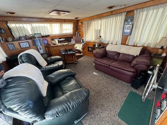 Slide: The Image of Cozy living area in a 1994 Gibson 44 Standard boat with leather seating and wood paneling. - 26