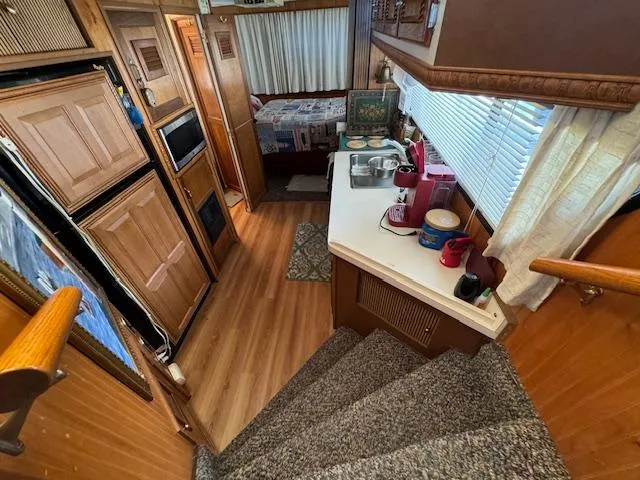 Slide: The Image of Interior of a 1994 Gibson 44 Standard houseboat with kitchen and bedroom view. - 27