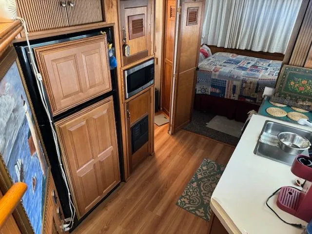 Slide: The Image of Interior of a 1994 Gibson 44 Standard houseboat with kitchen and bedroom view. - 28