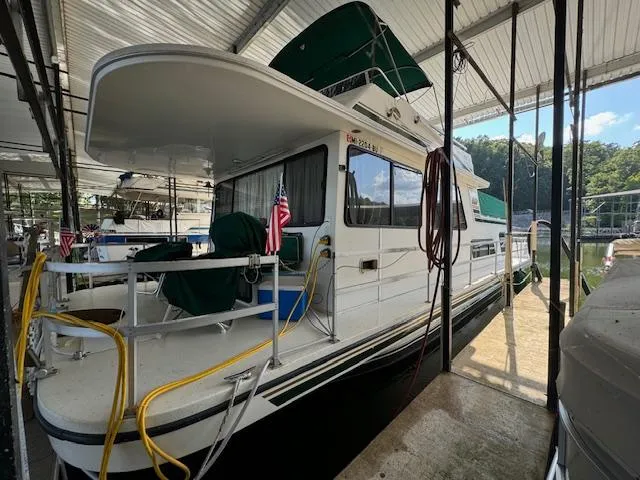 Slide: The Image of 1994 Gibson 44 Standard houseboat docked under a covered marina. - 3