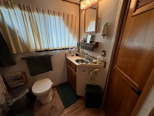 Slide: The Image of Cozy bathroom in a 1994 Gibson 44 Standard boat, featuring sink, toilet, and wooden cabinetry. - 35