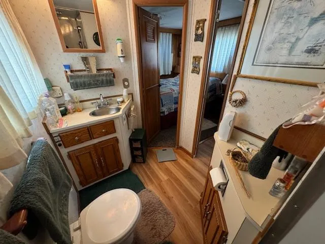 Slide: The Image of Cozy bathroom with wooden cabinets, sink, and toilet in a 1994 Gibson 44 Standard. - 39