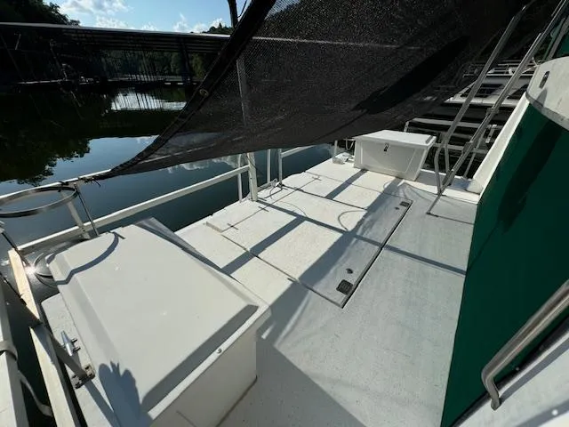 Slide: The Image of 1994 Gibson 44 Standard boat deck with canopy, docked by calm water. - 46