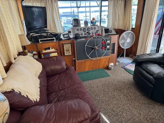 Slide: The Image of Cozy 1994 Gibson 44 Standard boat interior with helm, leather sofa, and TV. - 9