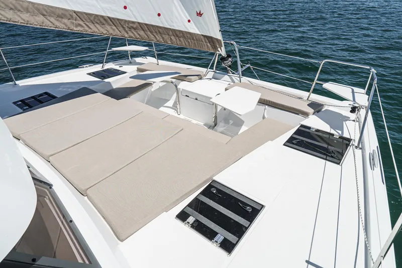 Slide: The Image of 2025 Bali CATSPACE catamaran deck with sun loungers and table on open water. - 24