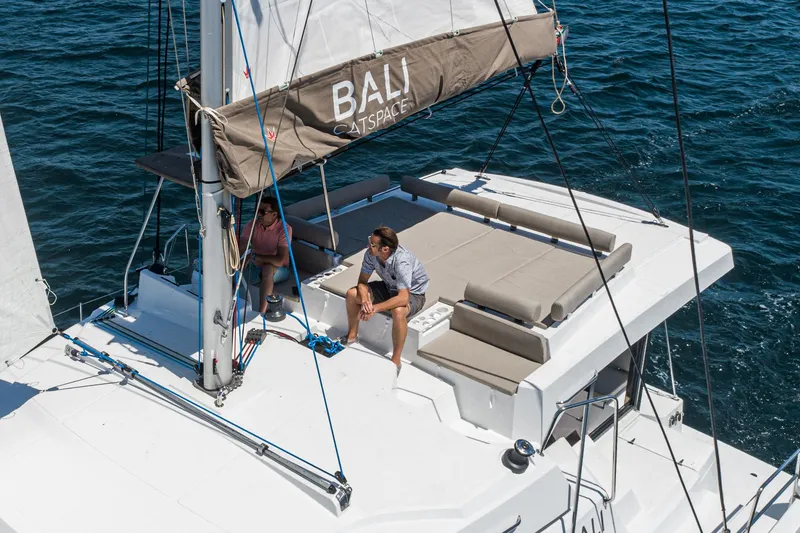 Slide: The Image of 2025 Bali CATSPACE catamaran sailing on open water with passengers relaxing on deck. - 27