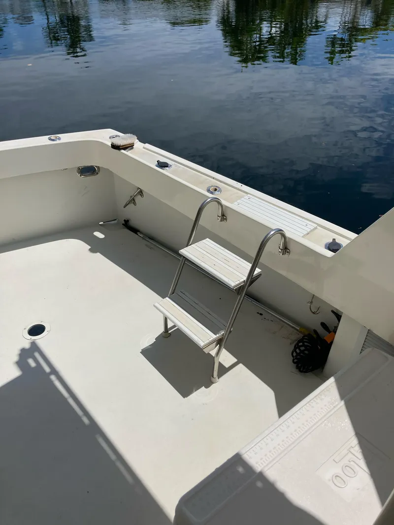 Slide: The Image of 1976 Hatteras 46 boat deck with ladder, reflecting on calm water. - 15
